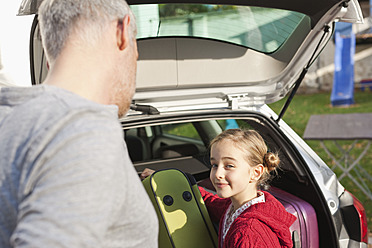 Germany, Leipzig, Father and daughter loading luggage into car - WESTF018426