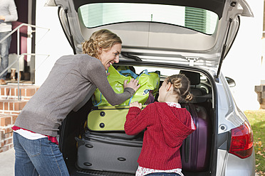 Deutschland, Leipzig, Mutter und Tochter laden Gepäck ins Auto - WESTF018427