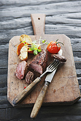 Germany, Bremen, Steak with vegetable on chopping board - KSWF000804