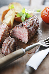 Germany, Bremen, Steak with vegetable on chopping board - KSWF000803