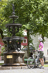 Österreich, Salzburger Land, Mittlere erwachsene Frau steht am Brunnen - DSF000262