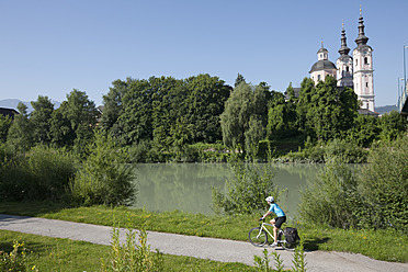 Austria, Carinthia, Villach, Mid adult woman riding bicycle - DSF000264