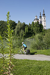 Austria, Carinthia, Villach, Mid adult woman riding bicycle - DSF000265