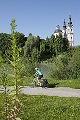Österreich, Kärnten, Villach, Mittlere erwachsene Frau fährt Fahrrad - DSF000265