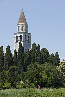 Italien, Aquileia, Mittlere erwachsene Frau fährt Fahrrad - DSF000279