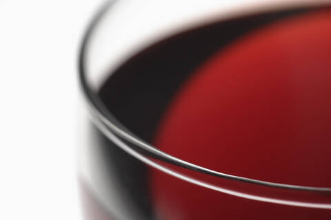 Glas Rotwein vor weißem Hintergrund, lizenzfreies Stockfoto