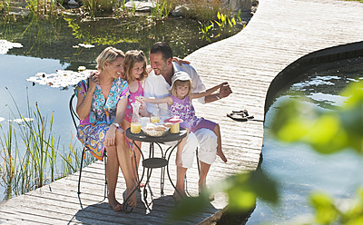 Österreich, Land Salzburg, Familie beim Frühstück auf der Brücke über den Teich - HHF003956