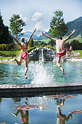 Österreich, Bundesland Salzburg, Paar springt ins Schwimmbad - HHF003961