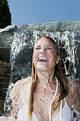 Österreich, Land Salzburg, Junge Frau unter Wasserfall - HHF003969