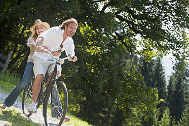 Austria, Salzburg County, Couple riding old bicycle - HHF003978