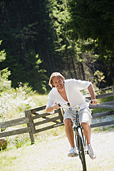 Österreich, Bundesland Salzburg, Mittlerer erwachsener Mann auf altem Fahrrad - HHF003981