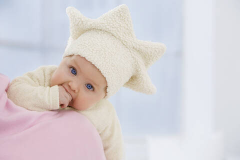 Baby-Mädchen in Sternform Hut mit Finger im Mund, lizenzfreies Stockfoto