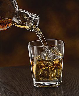 Einschenken von Whisky in einen Becher, Nahaufnahme - JLF000361