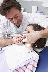 Deutschland, Bayern, Zahnarzt bei der Untersuchung eines Patienten - MAEF004488