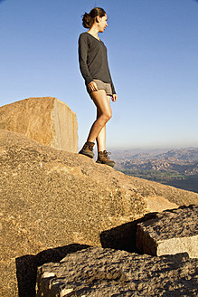 Indien, Karnataka, Hampi, Junge Frau geht auf Felsen - MBEF000267