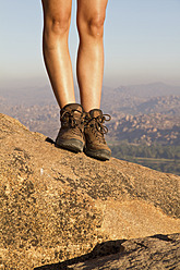 Indien, Karnataka, Hampi, Junge Frau geht auf Felsen - MBEF000268