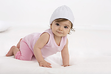 Baby girl crawling on baby blanket, smiling - SMOF000505