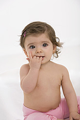 Baby-Mädchen sitzt auf Babydecke mit Finger im Mund - SMOF000506