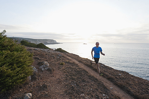 Portugal, Algarve, Älterer Mann joggt an der Küste - MIRF000365