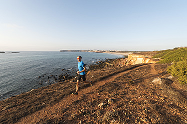 Portugal, Algarve, Älterer Mann joggt an der Küste - MIRF000367