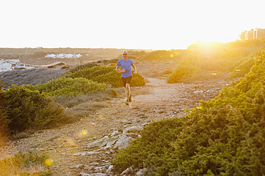 Portugal, Algarve, Älterer Mann joggt an der Küste - MIRF000371