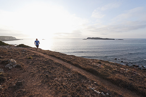 Portugal, Algarve, Älterer Mann joggt an der Küste - MIRF000373