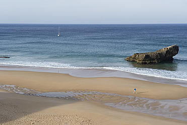 Portugal, Algarve, Ältere Frau joggt an der Küste - MIRF000375