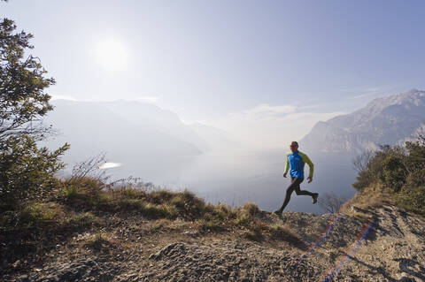 Italy, Mature man jogging by Lake Garda stock photo