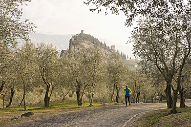Italien, Älterer Mann joggt auf einem Weg - MIRF000398