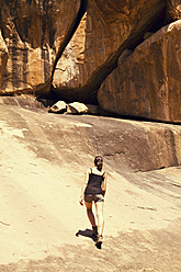 Indien, Karnataka, Hampi, Junge Frau geht auf Felsen - MBEF000265