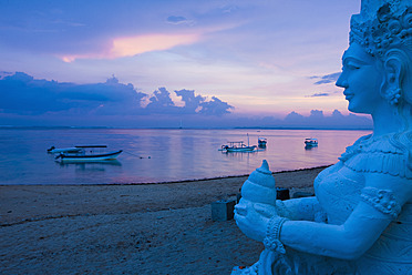 Indonesia, Bali, Sanur, Statue with sea in background at dusk - DSF000299