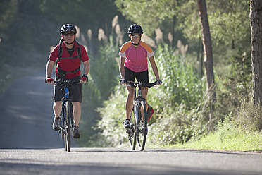 Spanien, Ibiza, Reifer Mann und mittlere erwachsene Frau fahren Fahrrad - DSF000382