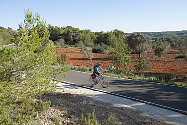 Spanien, Ibiza, Älterer Mann fährt Fahrrad - DSF000313