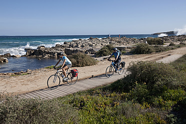 Spanien, Formentera, Älterer Mann und mittlere erwachsene Frau fahren Fahrrad - DSF000315