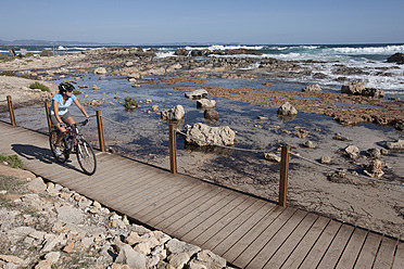 Spain, Formetera, Mid adult woman riding bicycle - DSF000383