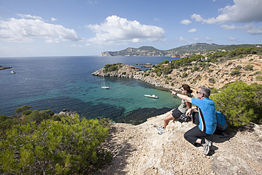 Spanien, Ibiza, Porroig, Reifer Mann und mittlere erwachsene Frau mit Blick auf die Aussicht - DSF000324