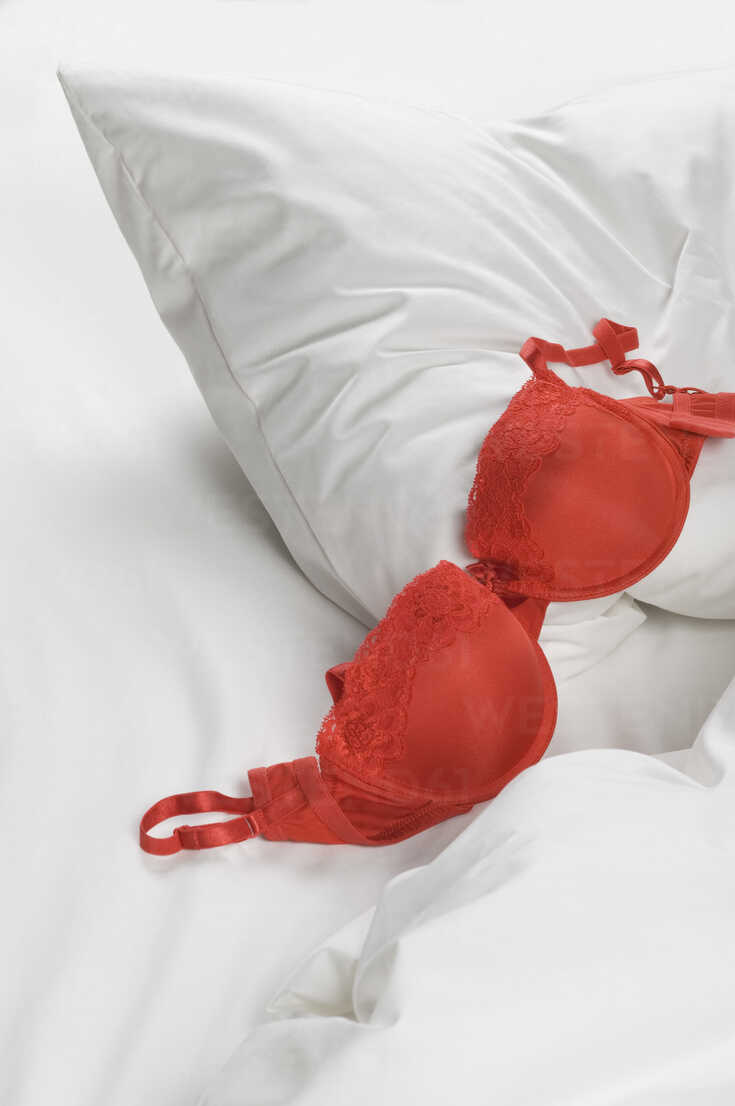 Red bra with pillow on bed stock photo