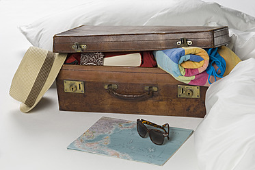 Suitcase with map on bed - CRF002139