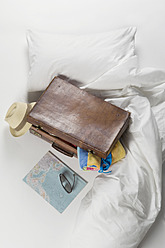 Suitcase with map on bed - CRF002140