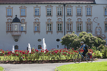Germany, Bavaria, Man cycling by Abbey Scheyern - DSF000327