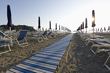 Italien, Ligurien, Sestri Levante, Reihe von Liegestühlen und Sonnenschirmen am Strand - DSF000335