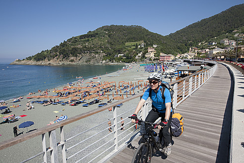 Italien, Ligurien, Bonassola, Älterer Mann fährt Fahrrad - DSF000338