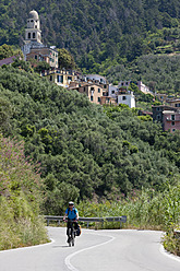 Italien, Ligurien, Legnaro, Älterer Mann fährt Fahrrad - DSF000339