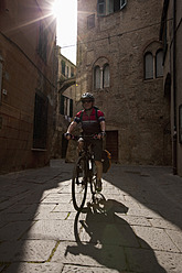 Italien, Ligurien, Albenga, Älterer Mann fährt Fahrrad - DSF000386