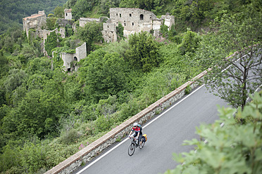 Italien, Ligurien, Erli, Älterer Mann fährt Fahrrad - DSF000355