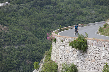 Italien, Ligurien, Provinz Savona, Älterer Mann fährt Fahrrad - DSF000359