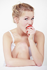 Junge Frau, die in einen Apfel beißt, Porträt - WVF000226