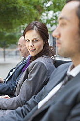 Germany, Leipzig, Business people sitting on bench, smiling - WESTF018582