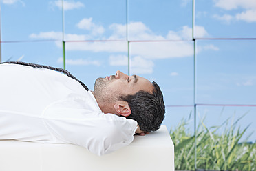 Germany, Leipzig, Businessman resting on cubes - WESTF018587