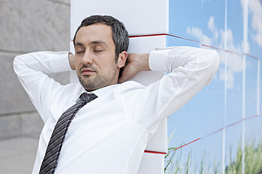 Germany, Leipzig, Businessman resting on cubes - WESTF018589